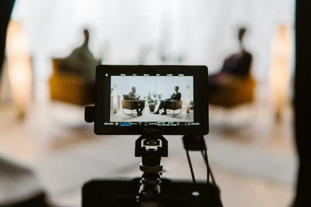 Camera monitor framing two people seated for a guided interview